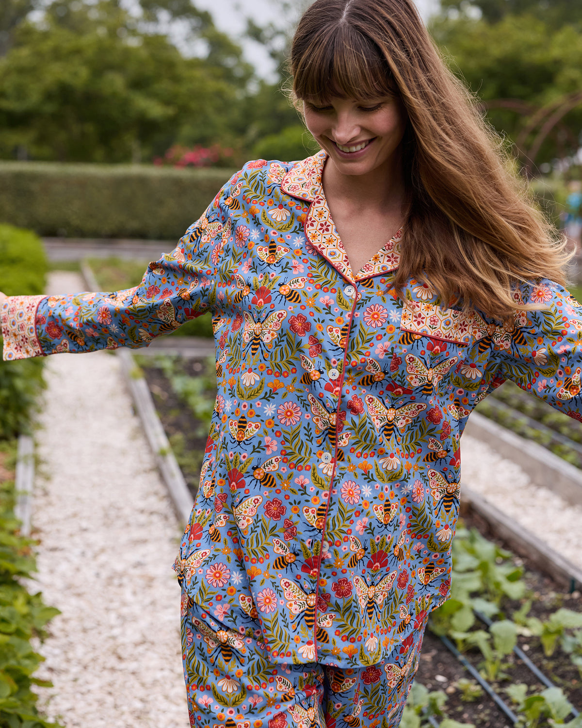 Close view of the Delphinium Blue Bee Tapestry petite long pajama set, showing the button-front top, chest pocket, patterned cuffs, and matching pants.