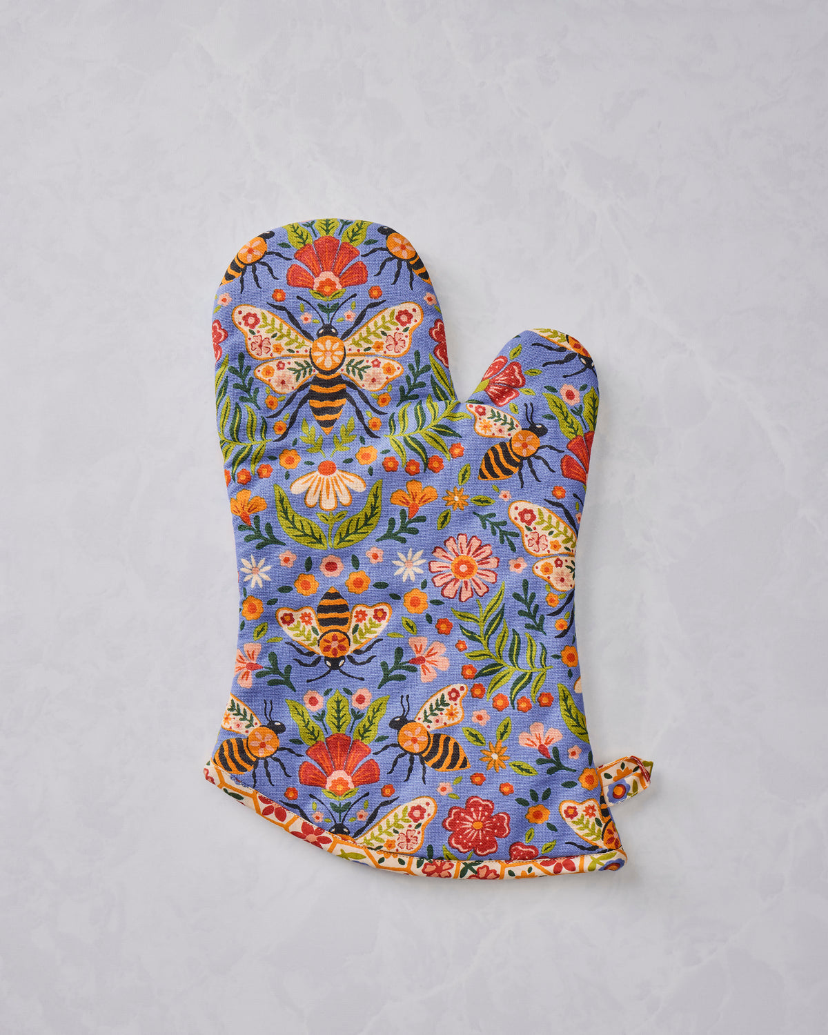 Single blue floral oven mitt printed with bees, butterflies, flowers, and leaves.