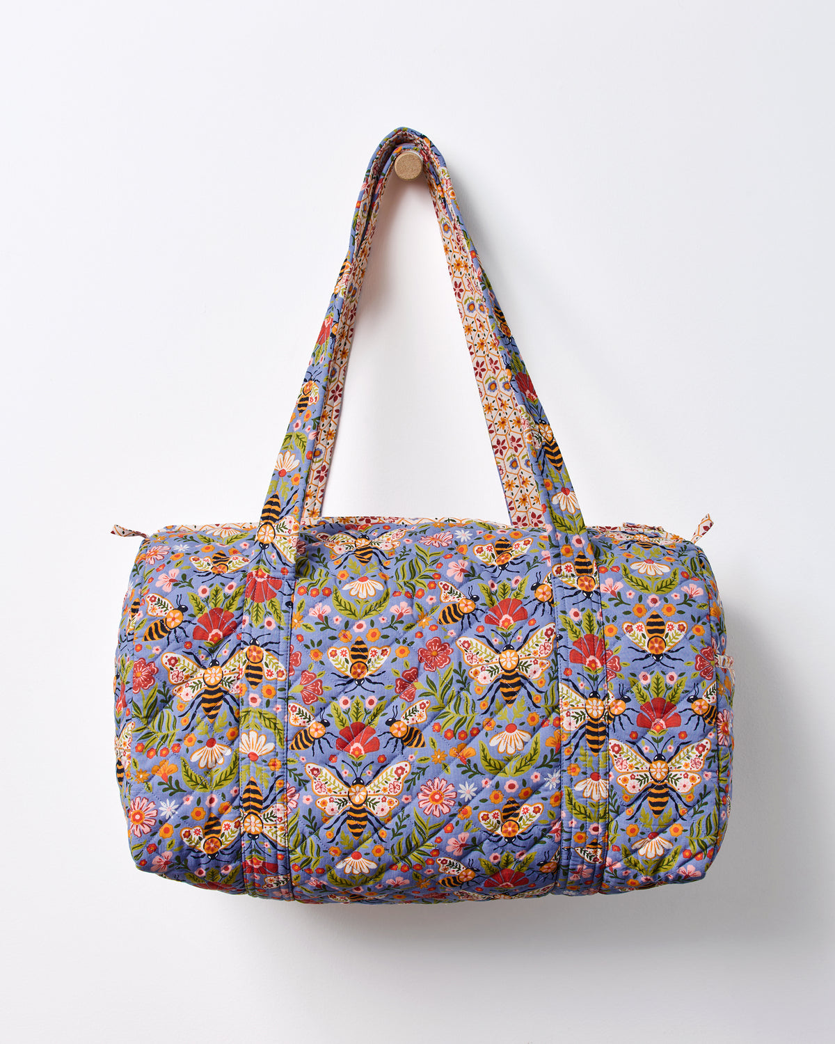 Blue Bee Tapestry quilted duffle bag shown front-facing with two handles and a top zipper.