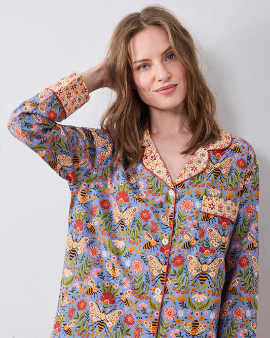 Close-up front view of the Bee Tapestry Delphinium Blue petite pajama top, showing its floral and bee print, contrasting collar and cuffs, buttons, and chest pocket.