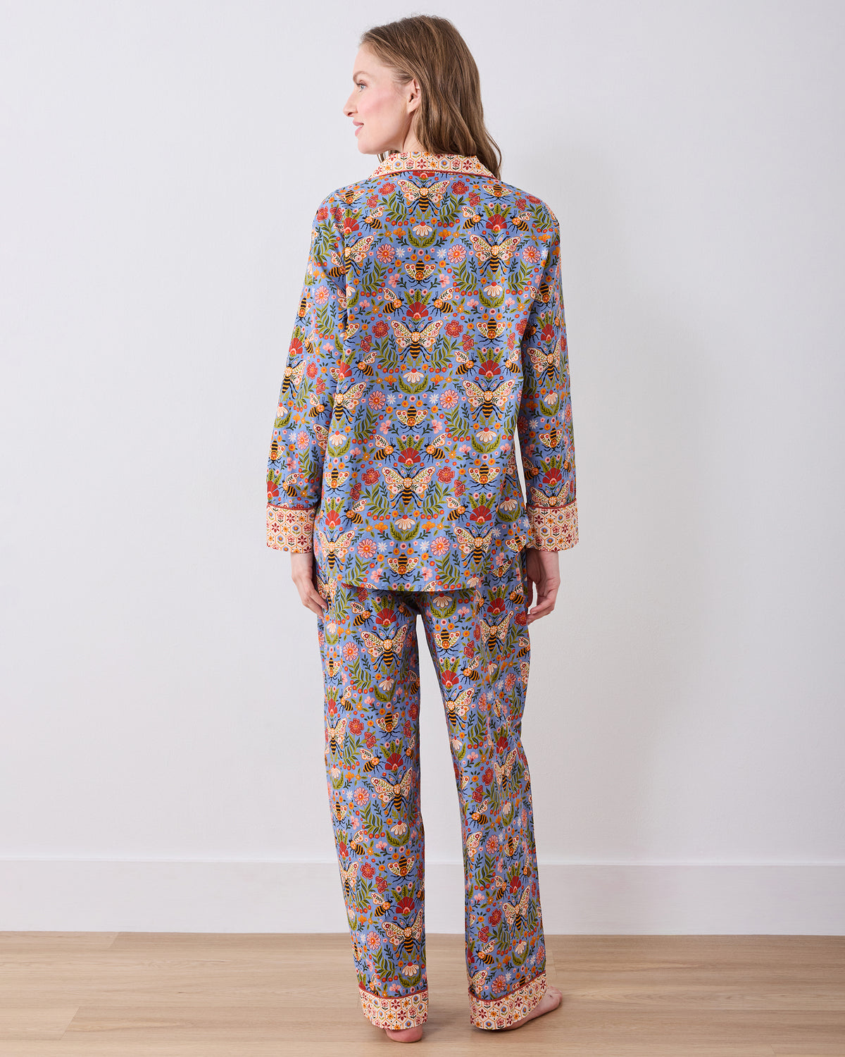 Back view of the Bee Tapestry Delphinium Blue long pajama set, showing the full-length button-down top and matching pants with contrasting cuffs and hem.