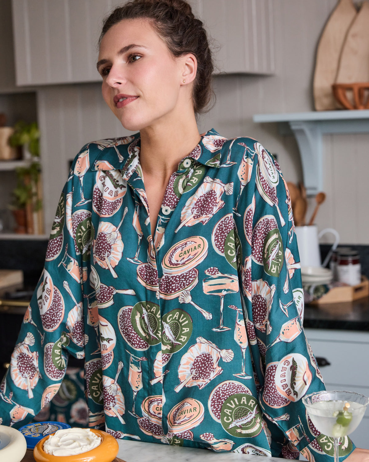 Close front view of the Champagne & Caviar Eco Satin Stevie pajama top in Peacock Feather print, showing the collar, buttons, sleeve shape, and patterned fabric.