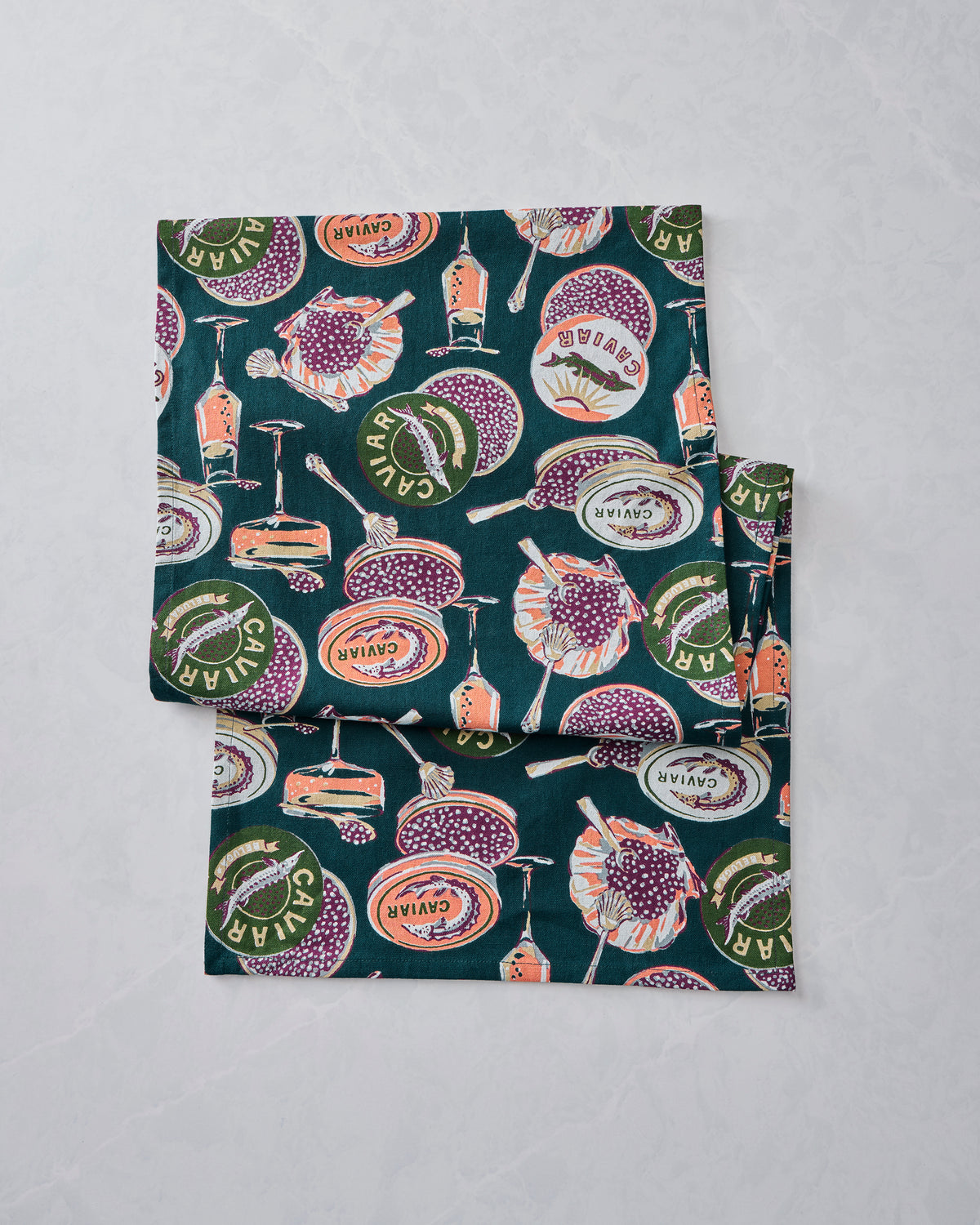 Folded Champagne & Caviar table runner displaying a repeating caviar and champagne-themed print.