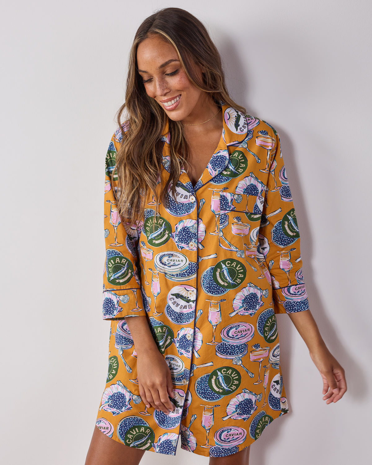Front view of the goldenrod Champagne & Caviar button-down sleep shirt with three-quarter sleeves and a caviar-themed print.