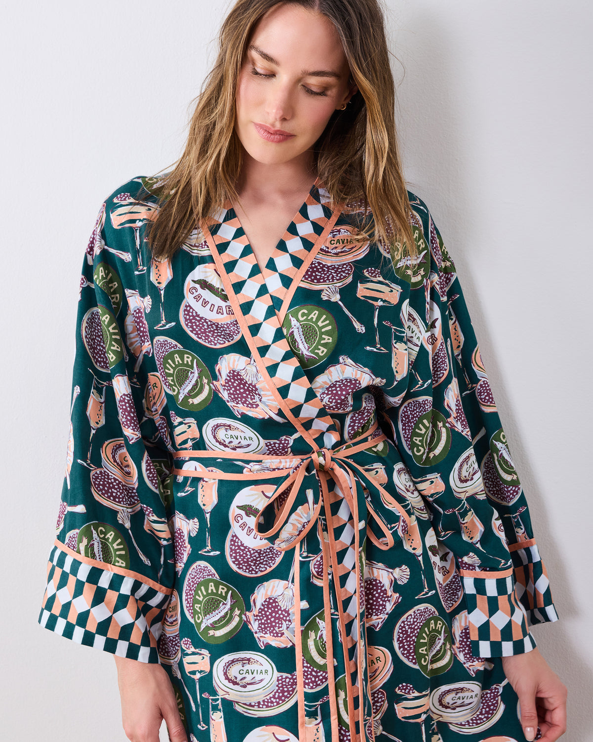 Front view of a printed wrap robe with long sleeves, contrast trim, and a tied waist.