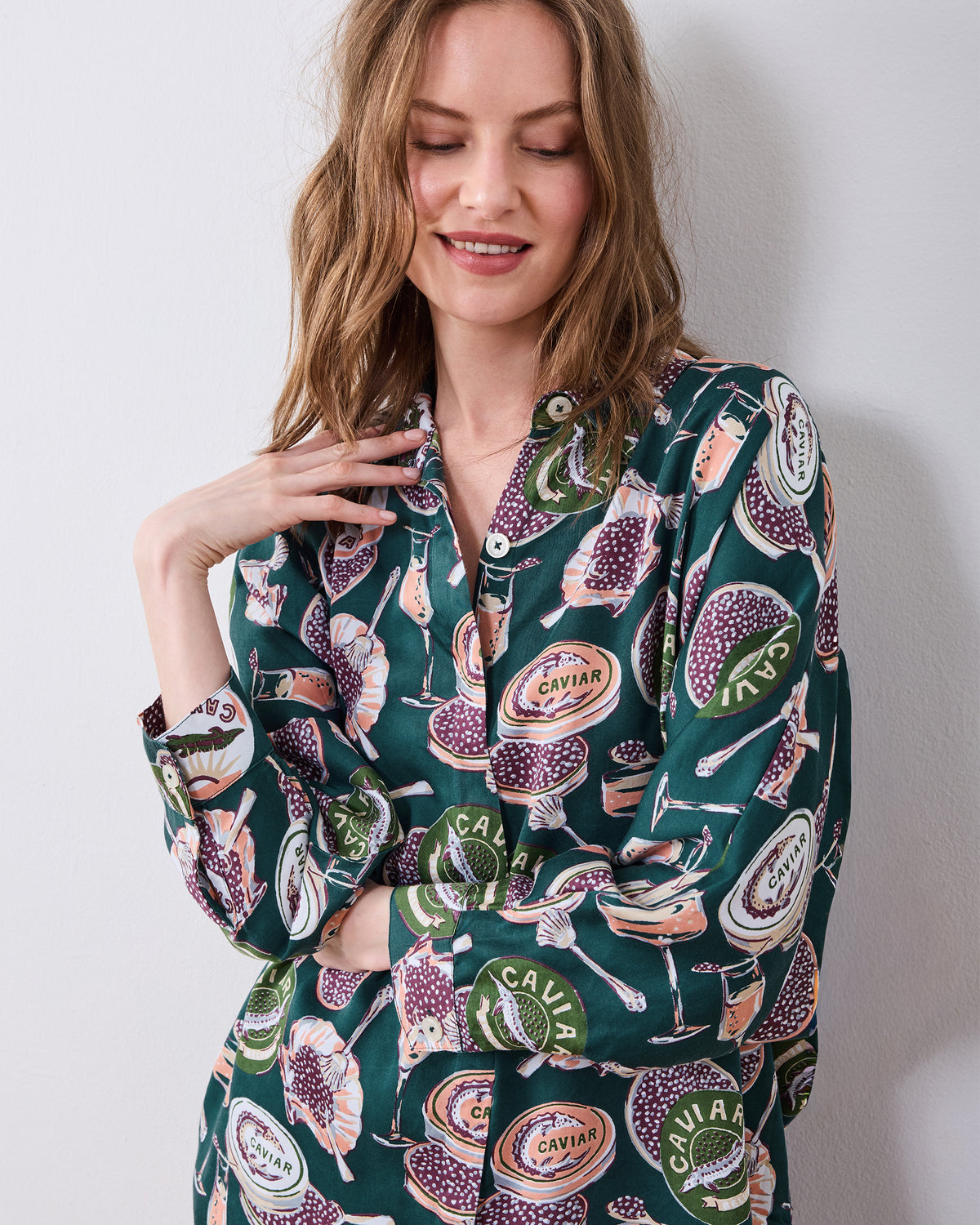 Close-up of the Champagne & Caviar Stevie pajama top showing its collar, buttons, cuff, and caviar and champagne flute print.