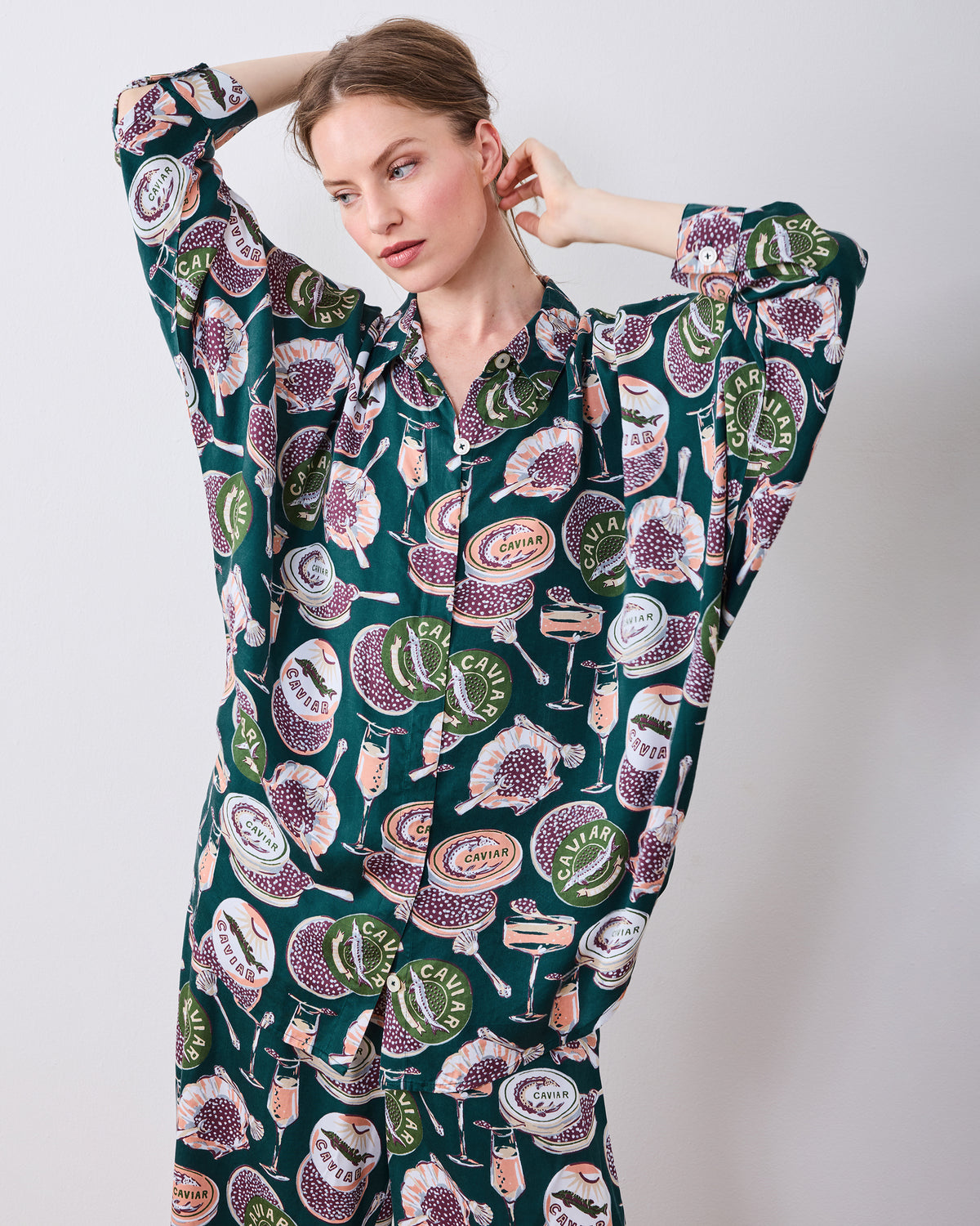 Close front view of the Champagne & Caviar Stevie pajama top with buttons, cuffed sleeves, and a caviar and champagne flute print.