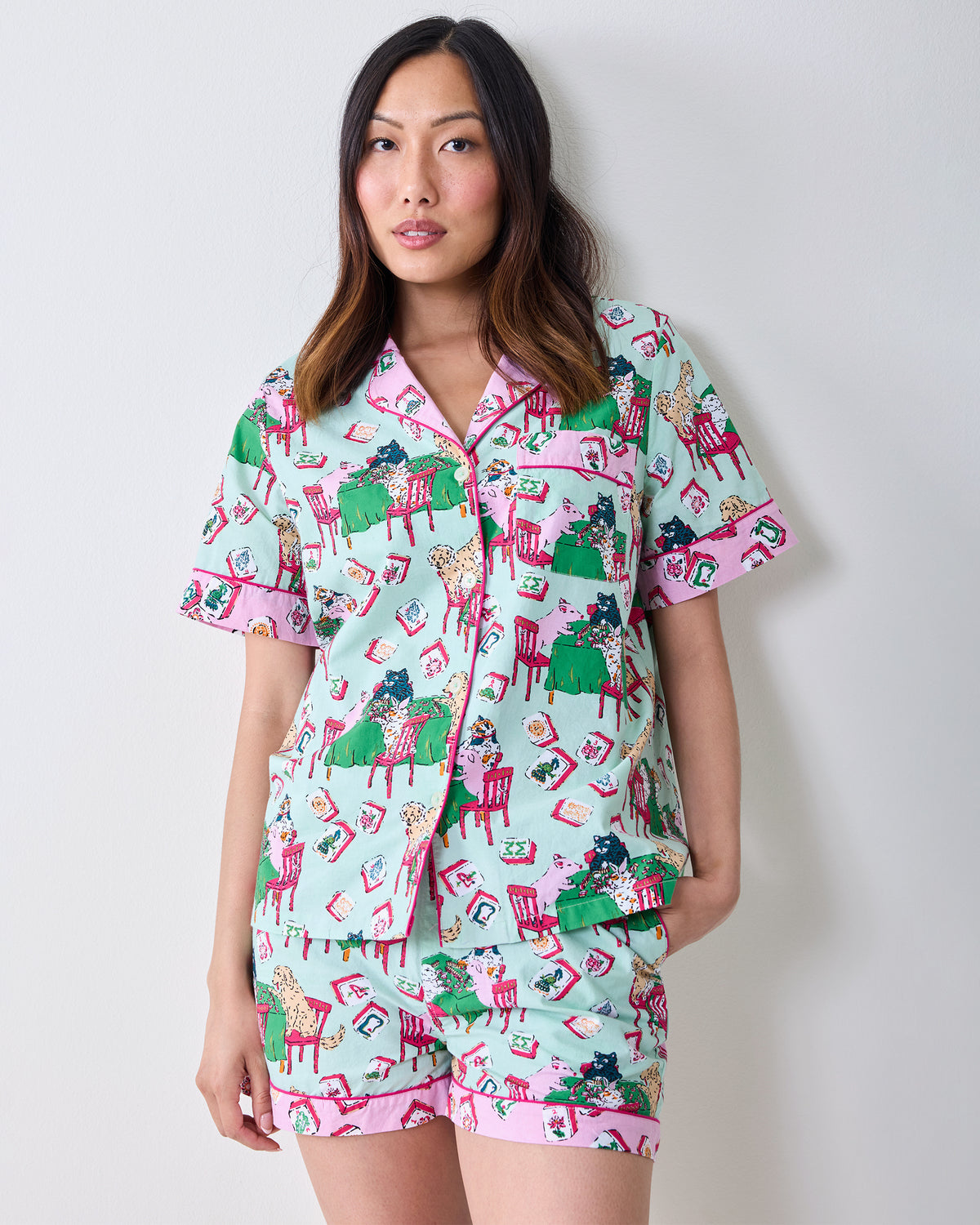 Person wearing the pale jade Mah Jongg Menagerie short pajama set with a button-front shirt and shorts featuring colorful tiles and animals.