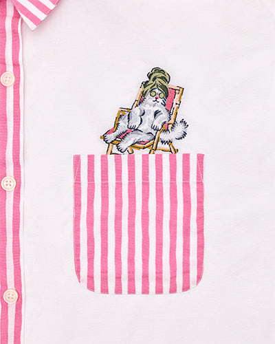 Close-up of pink-striped button-down pocket embroidered with a cat reclining in a chair