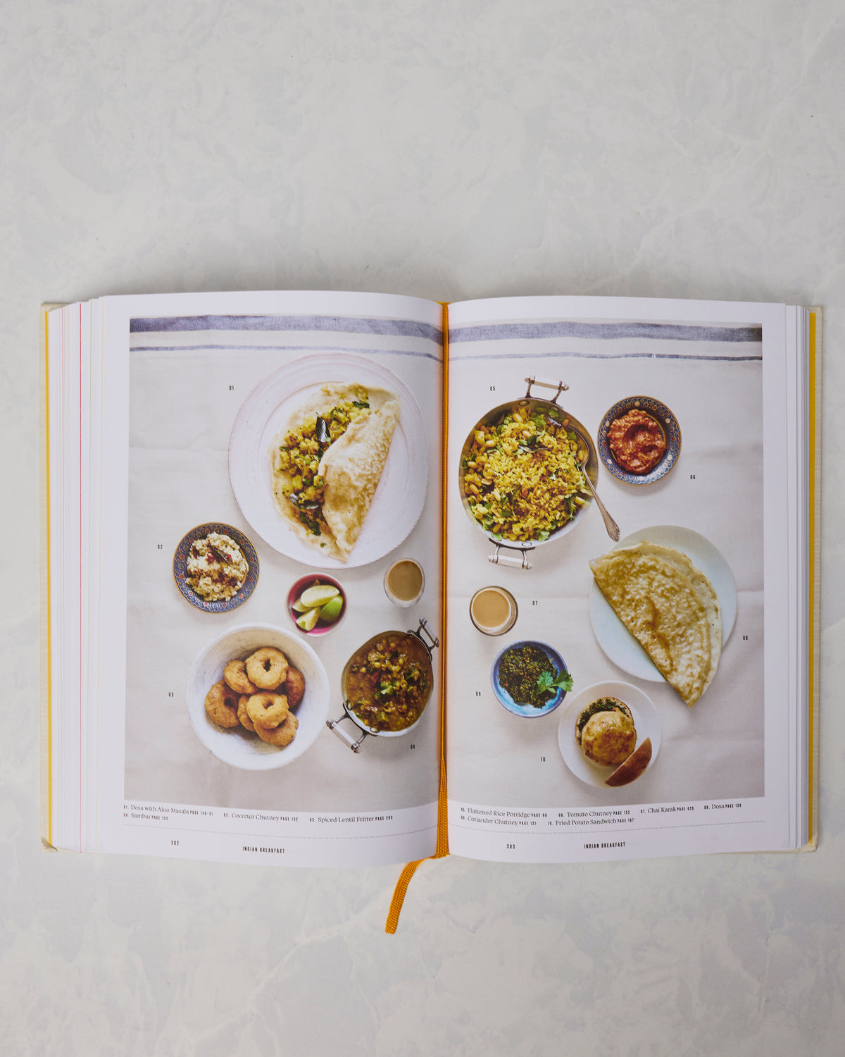 Open cookbook showing a two-page spread of arranged breakfast dishes photographed from above.