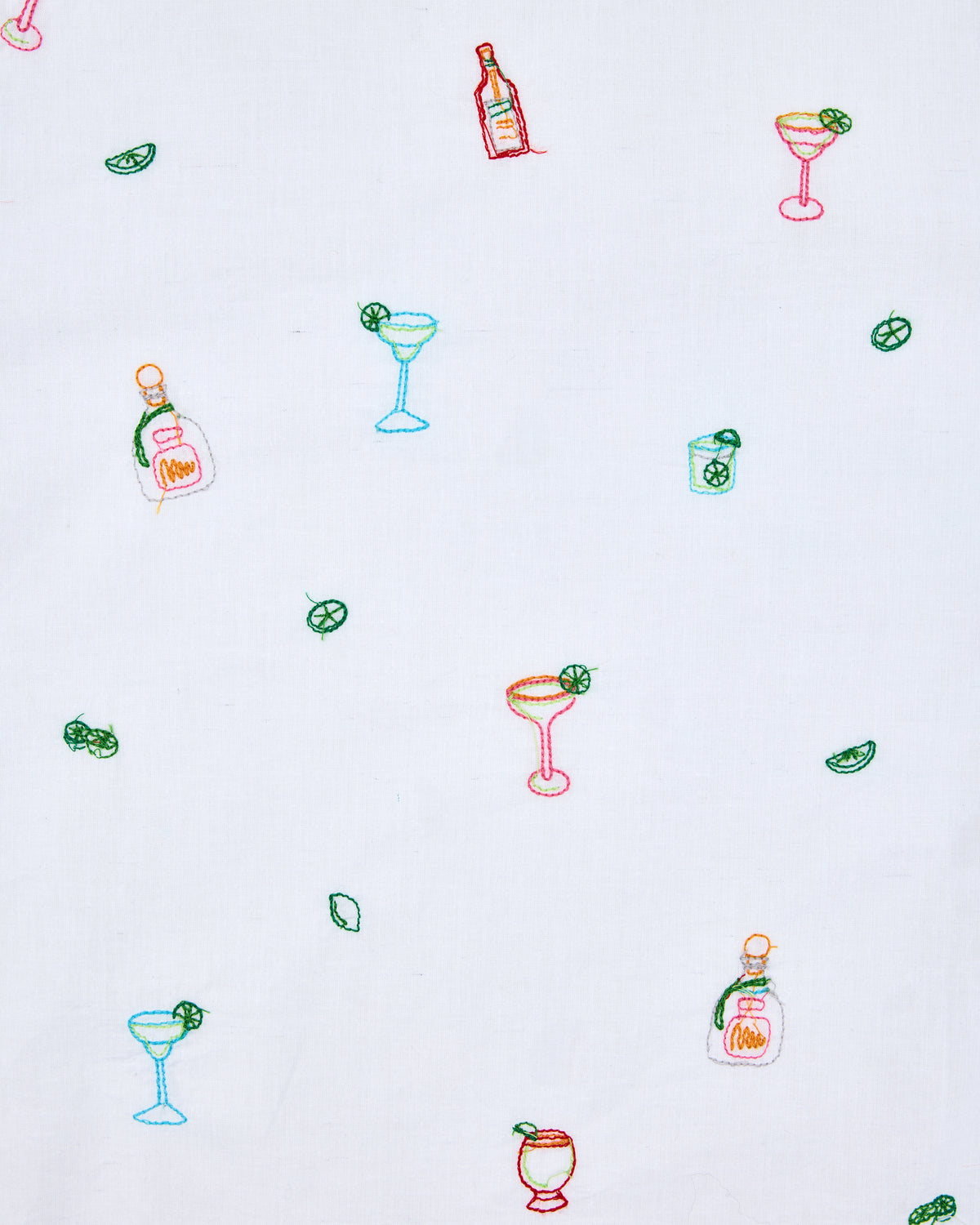 Close-up of the white fabric print featuring colorful cocktail bottles, margarita glasses, lime wedges, and other drinks.