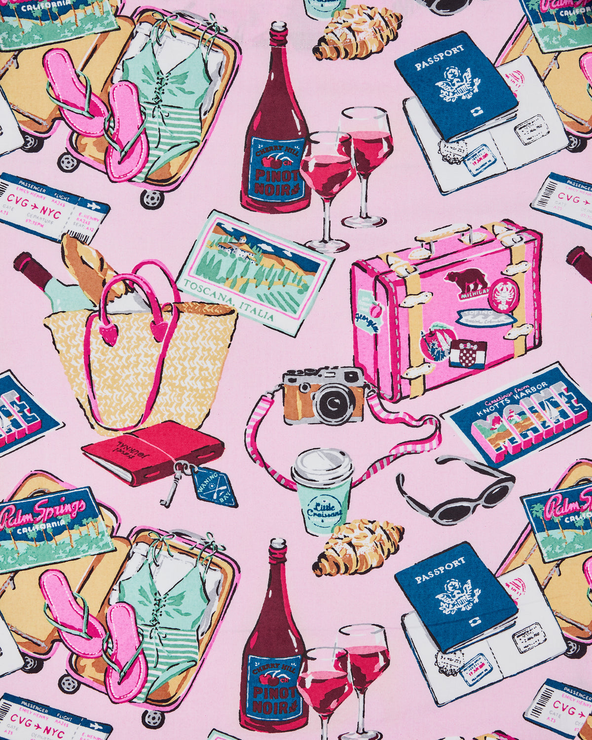 Close-up of the pink Emotional Baggage travel-themed print with passports, wine, luggage, cameras, sunglasses, postcards, and other travel illustrations.