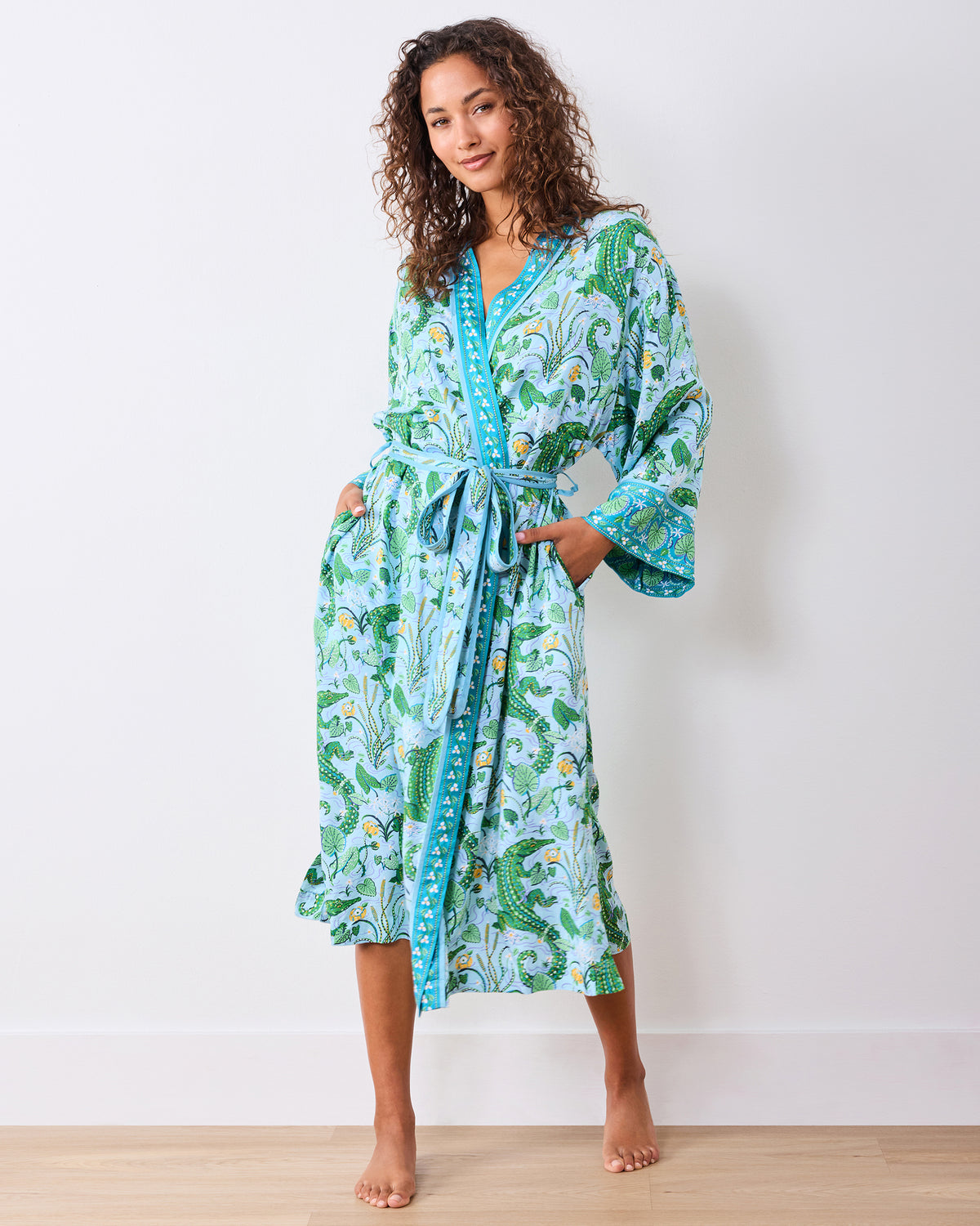 Front full-length view of the alligator-print robe worn belted with hands in the pockets