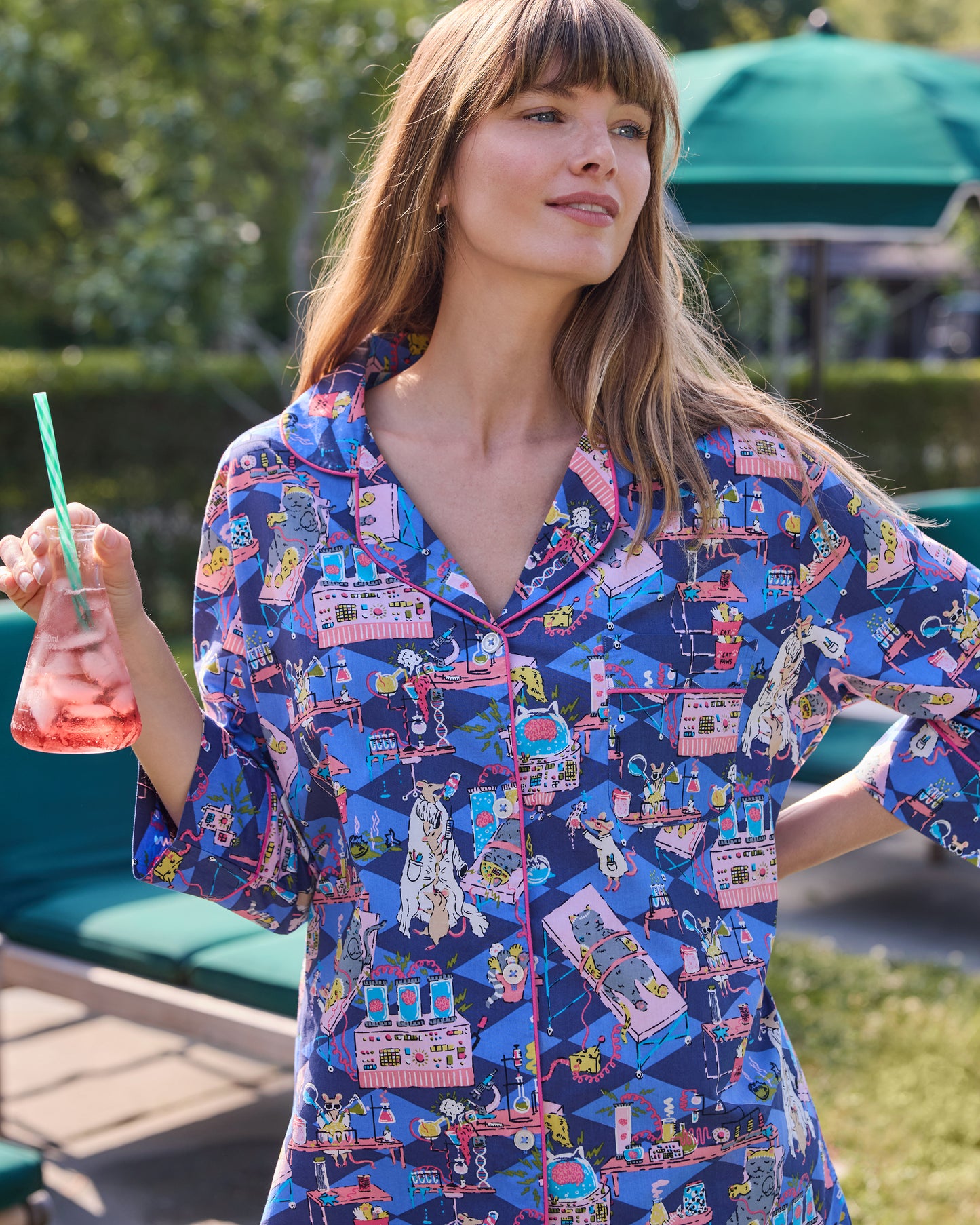 Close view of a blue button-down sleep shirt with a colorful mice-and-laboratory print and contrasting piping.