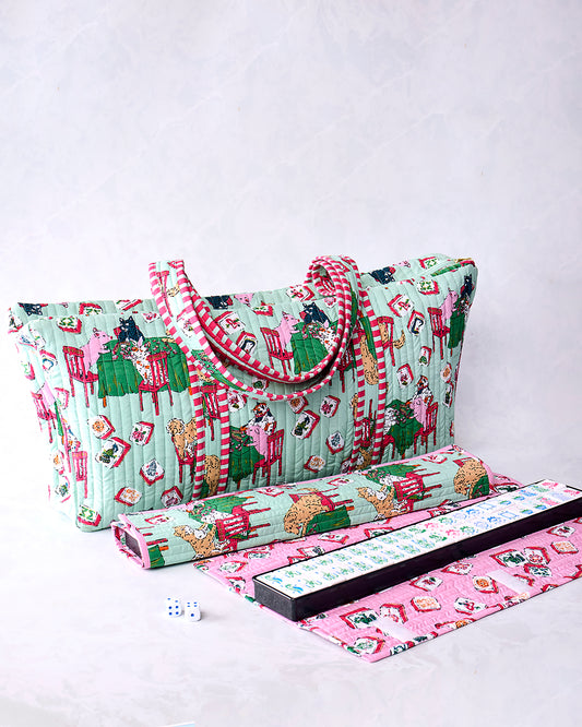 Pale jade quilted Mah Jongg bag with handles and a playful printed scene, shown with a rolled item, game rack, mat, and tiles.
