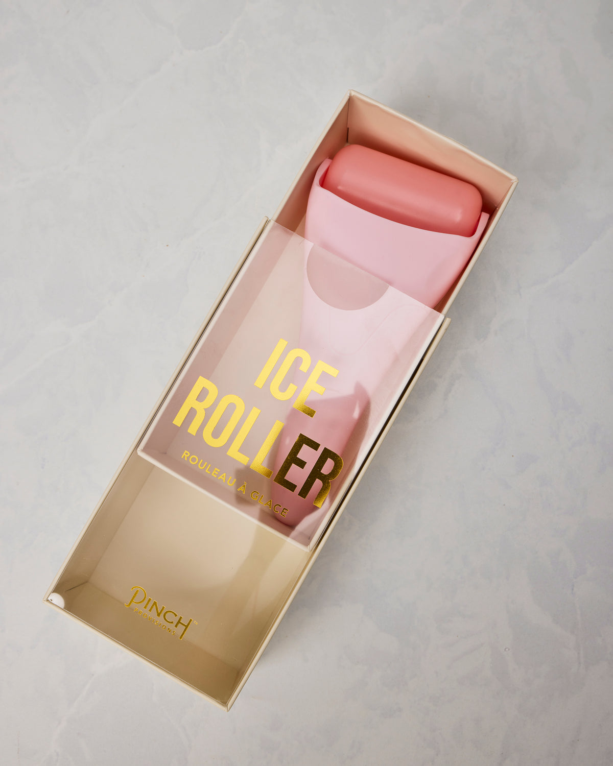 Angled view of the pink ice roller in its open presentation box, showing the box sleeve and roller head.