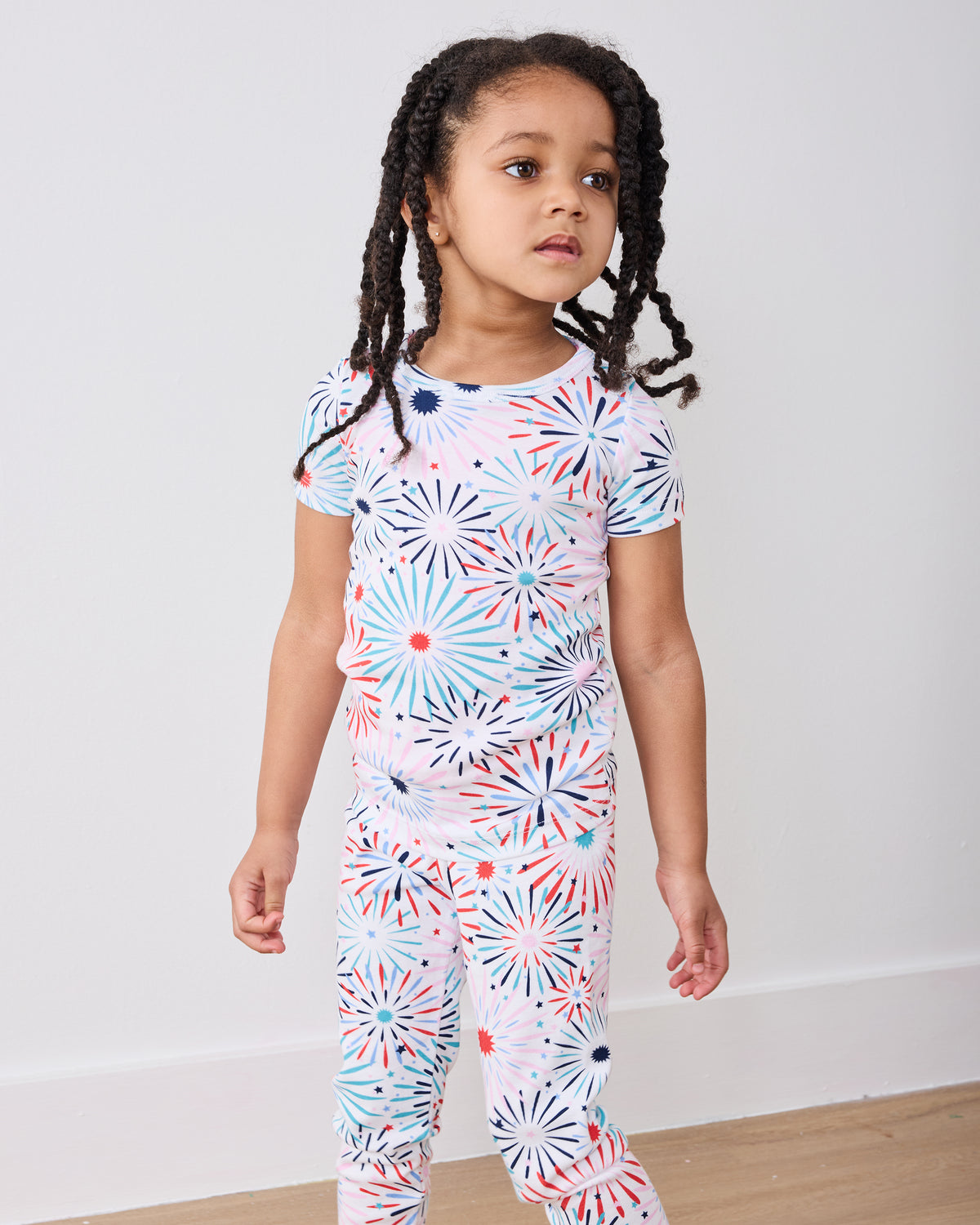 Standing front view of the fireworks-print short-sleeve pajama top and matching pants