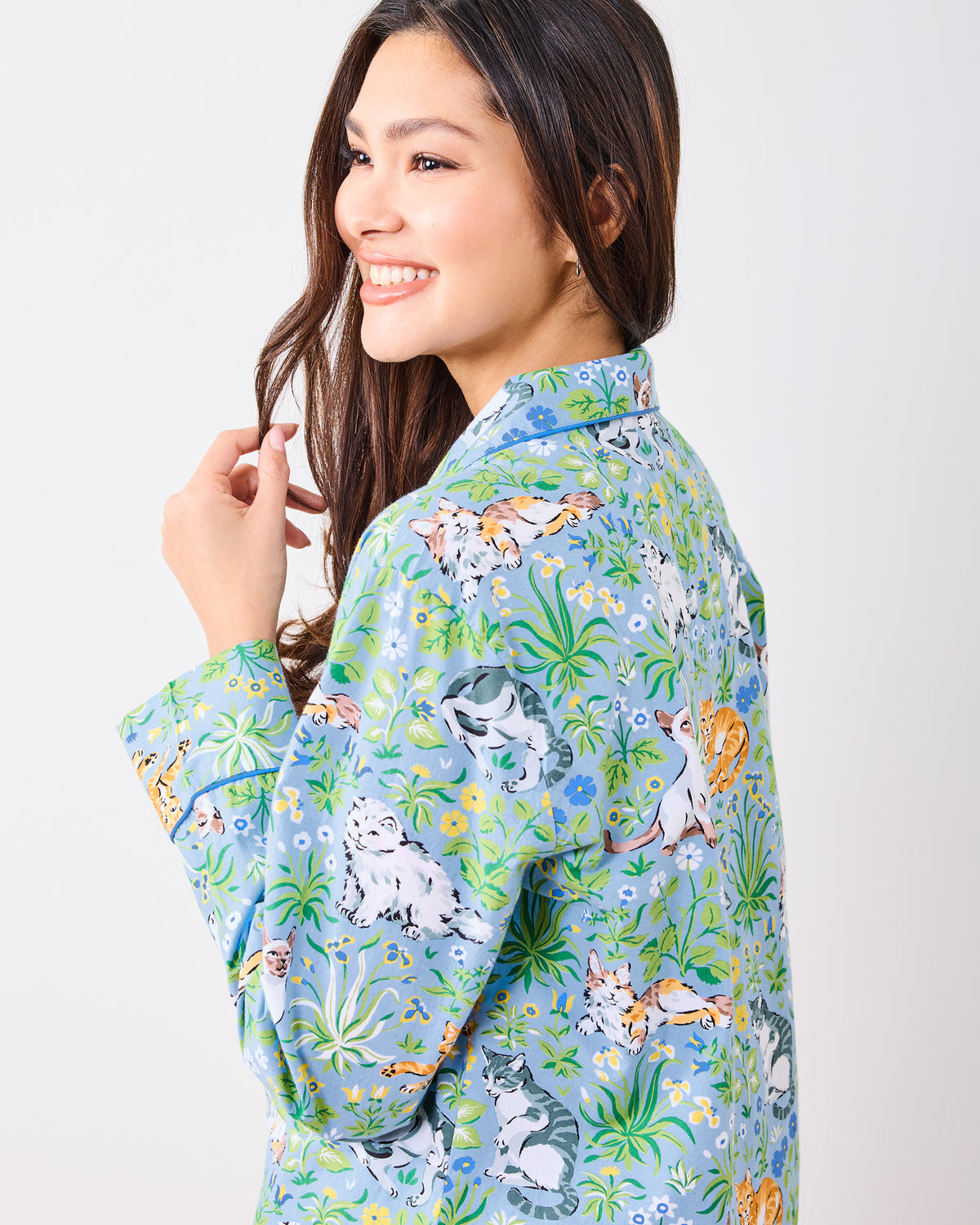 Close back and side view of the blue pajama top showing the cat and garden print