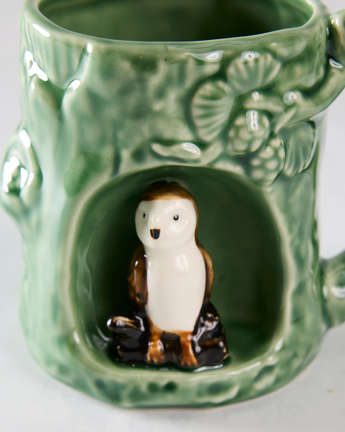 Close-up of the barn owl figurine in the green mug’s front alcove and the raised woodland details above it.