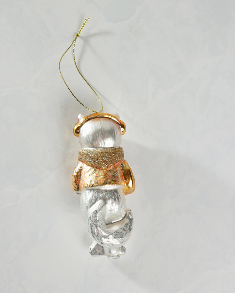 Back view of the silver-and-gold cat ornament showing its hanging cord, glittered clothing, and curled lower body.