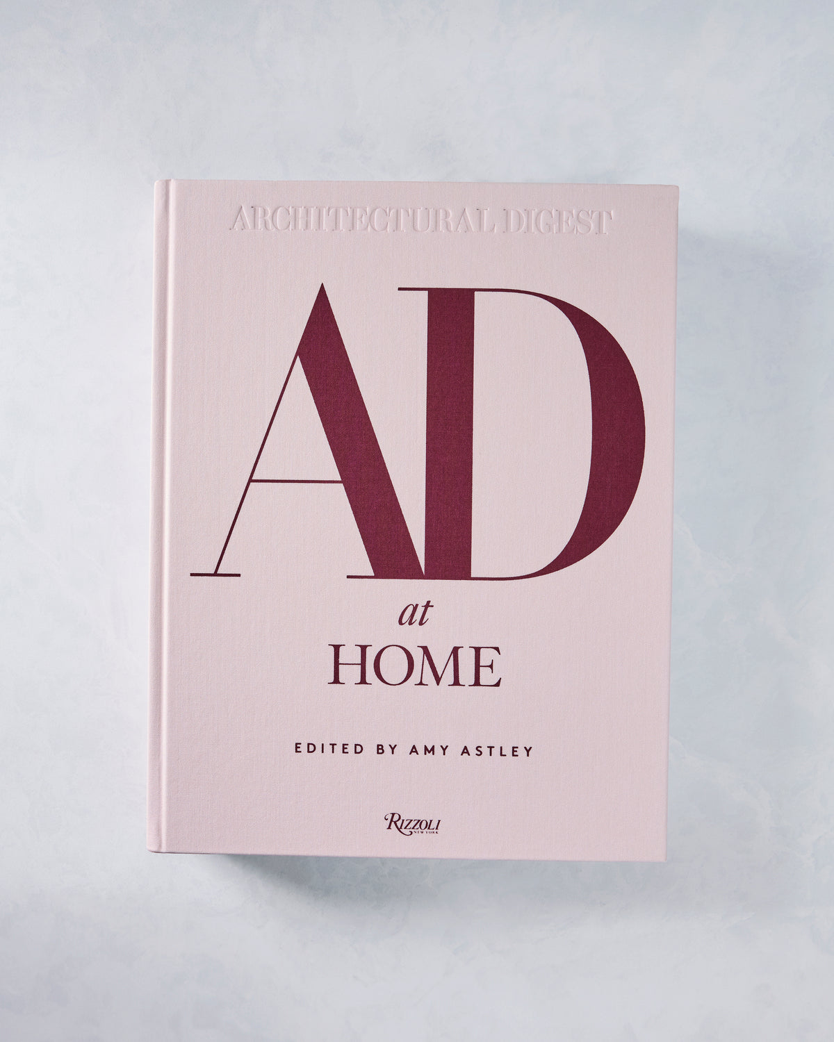 Front cover of the pale pink AD at Home book by Architectural Digest, edited by Amy Astley and published by Rizzoli.