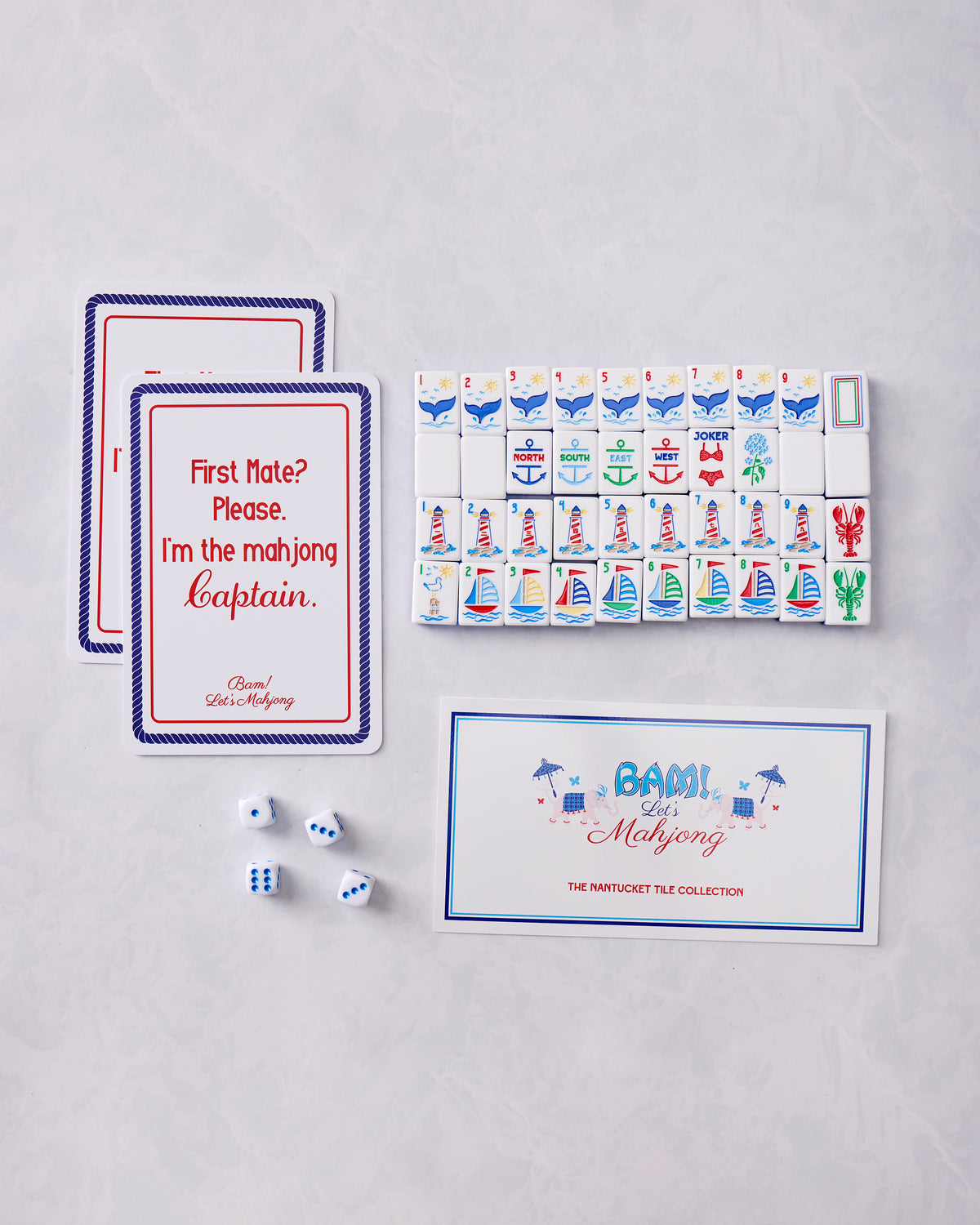Nantucket mahjong tile set arranged with two cards, four dice, and an illustrated collection box showing the nautical tile designs.