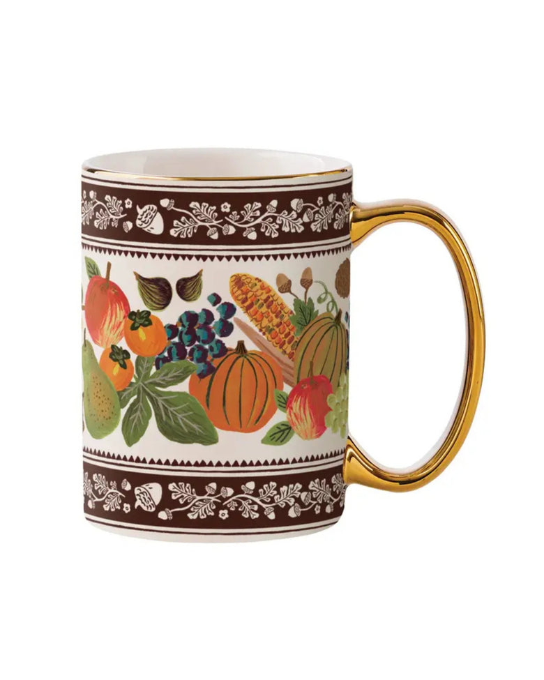 Brown porcelain mug with gold handle and rim, decorated with harvest fruits, vegetables, leaves, and acorn borders.