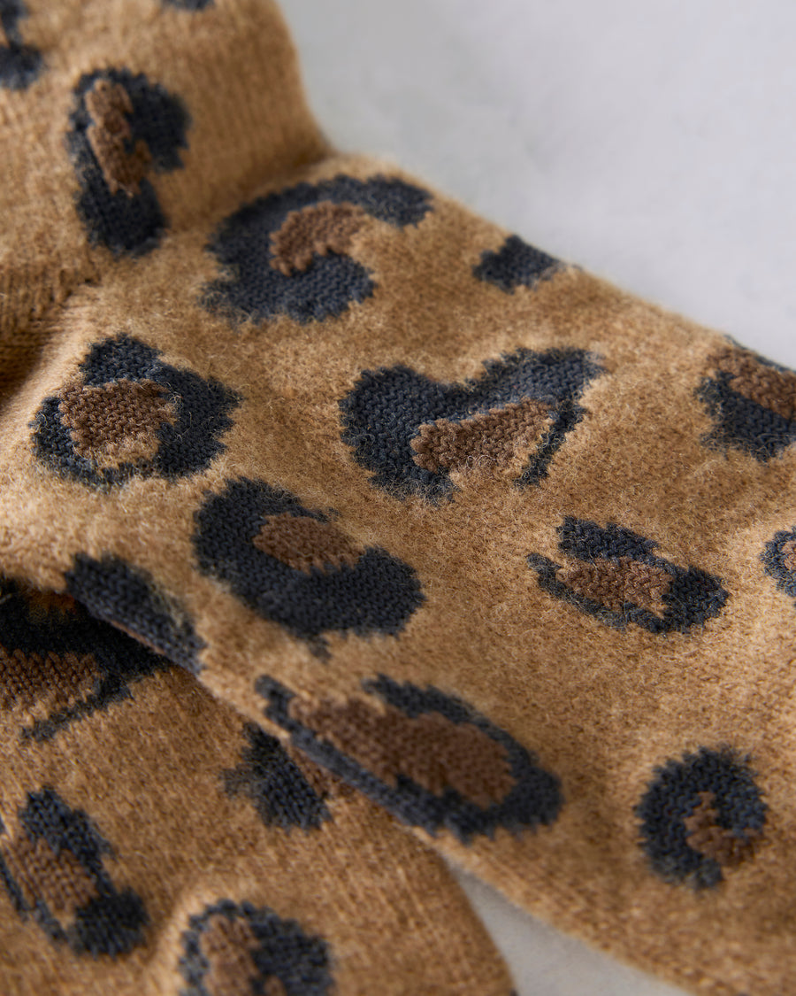 Close-up of the camel socks showing the textured knit and black-and-brown spot pattern.