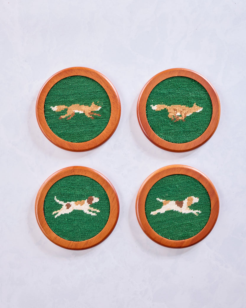 Four round Fox Chase coasters with embroidered fox motifs on green centers and chestnut-colored wooden rims.