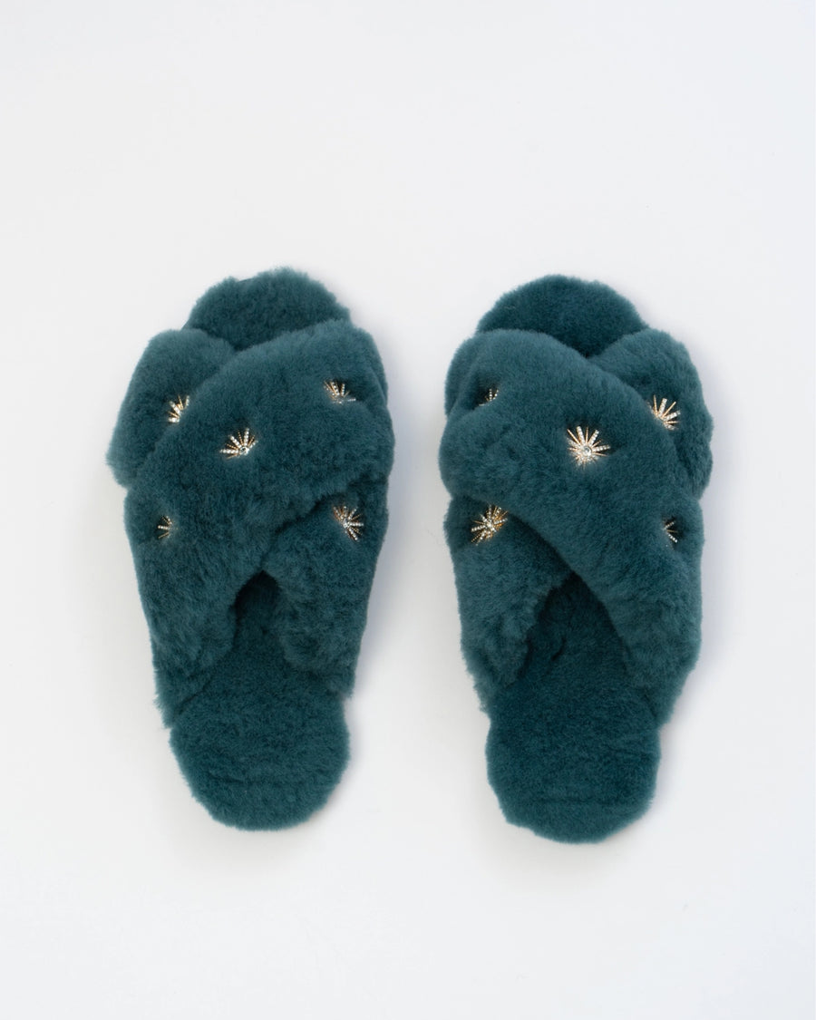 Dusty blue open-toe slippers with crossed plush straps and rhinestone embellishments, shown from above.