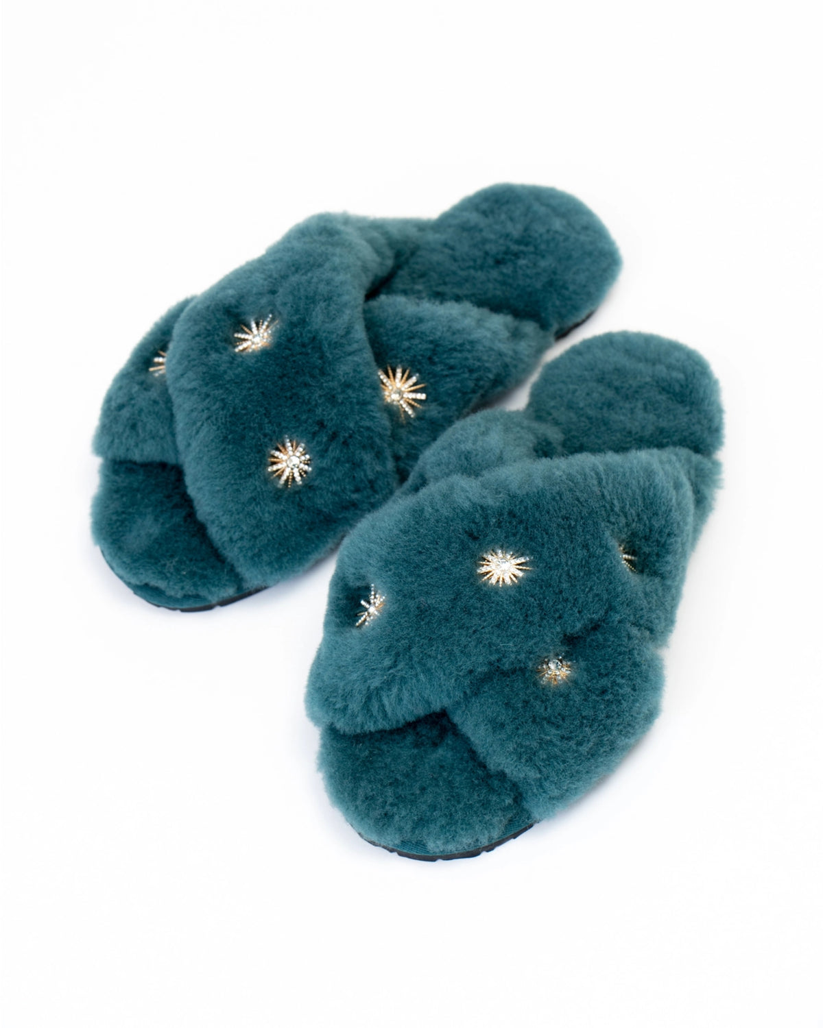 Dusty blue open-toe slippers with crossed plush straps and rhinestone embellishments, shown at an angle.