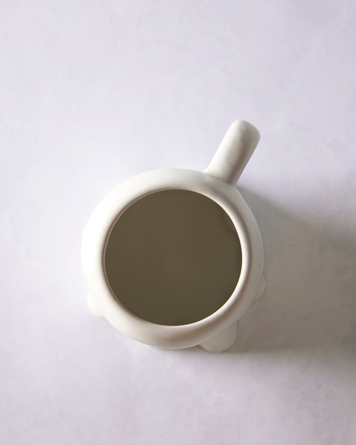 Top view of the white ghost mug showing its circular opening, handle, and ghost-shaped base.