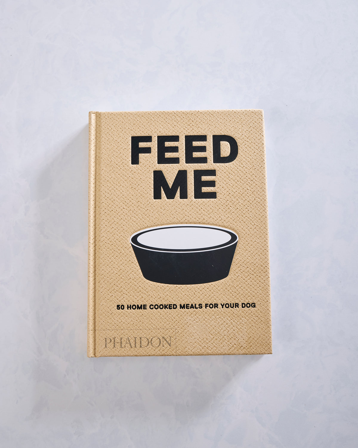 Front cover of Feed Me, featuring a bowl illustration and the subtitle 50 home cooked meals for your dog.