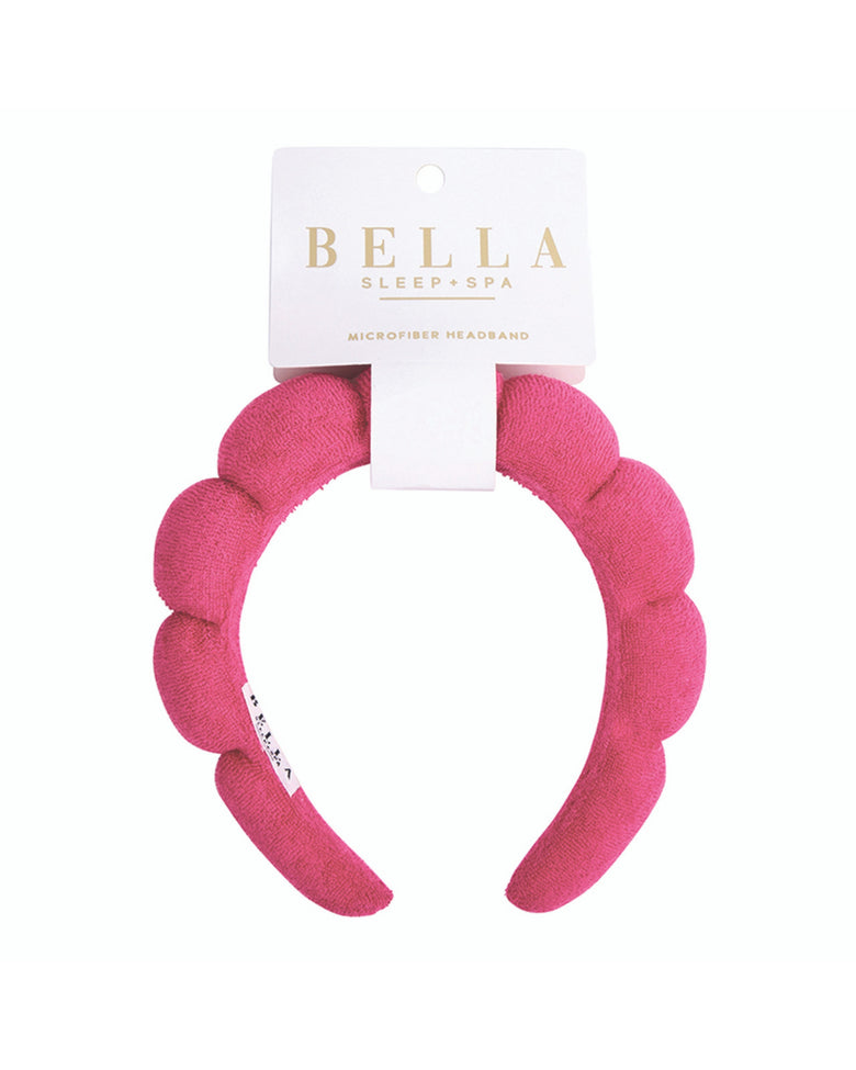Packaged hot pink plush spa headband with a scalloped padded design; label reads “BELLA SLEEP” and “MICROFIBER HEADBAND.”