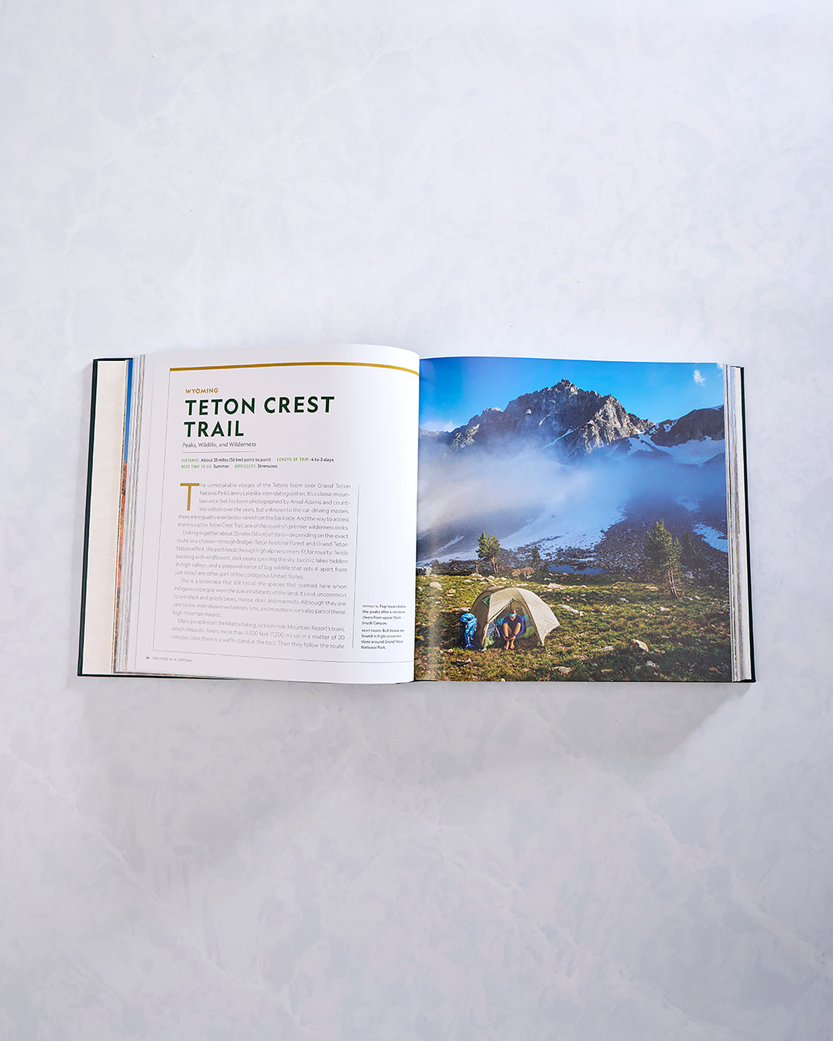 Open spread from the hiking book featuring a Teton Crest Trail entry and a mountain campsite photograph.