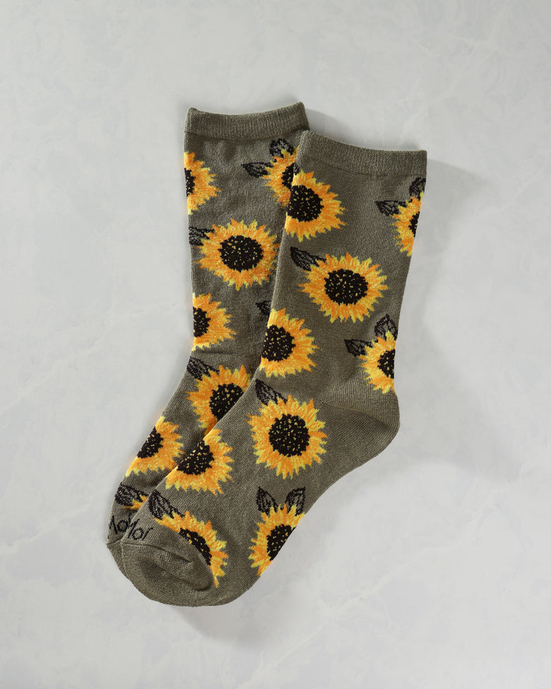 Pair of olive crew socks with an all-over yellow sunflower and black leaf pattern, shown overlapping.