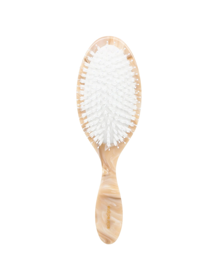 Front view of an ivory hair brush with dense white bristles