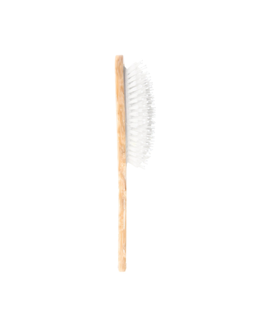Side view of an ivory hair brush showing the raised white bristles