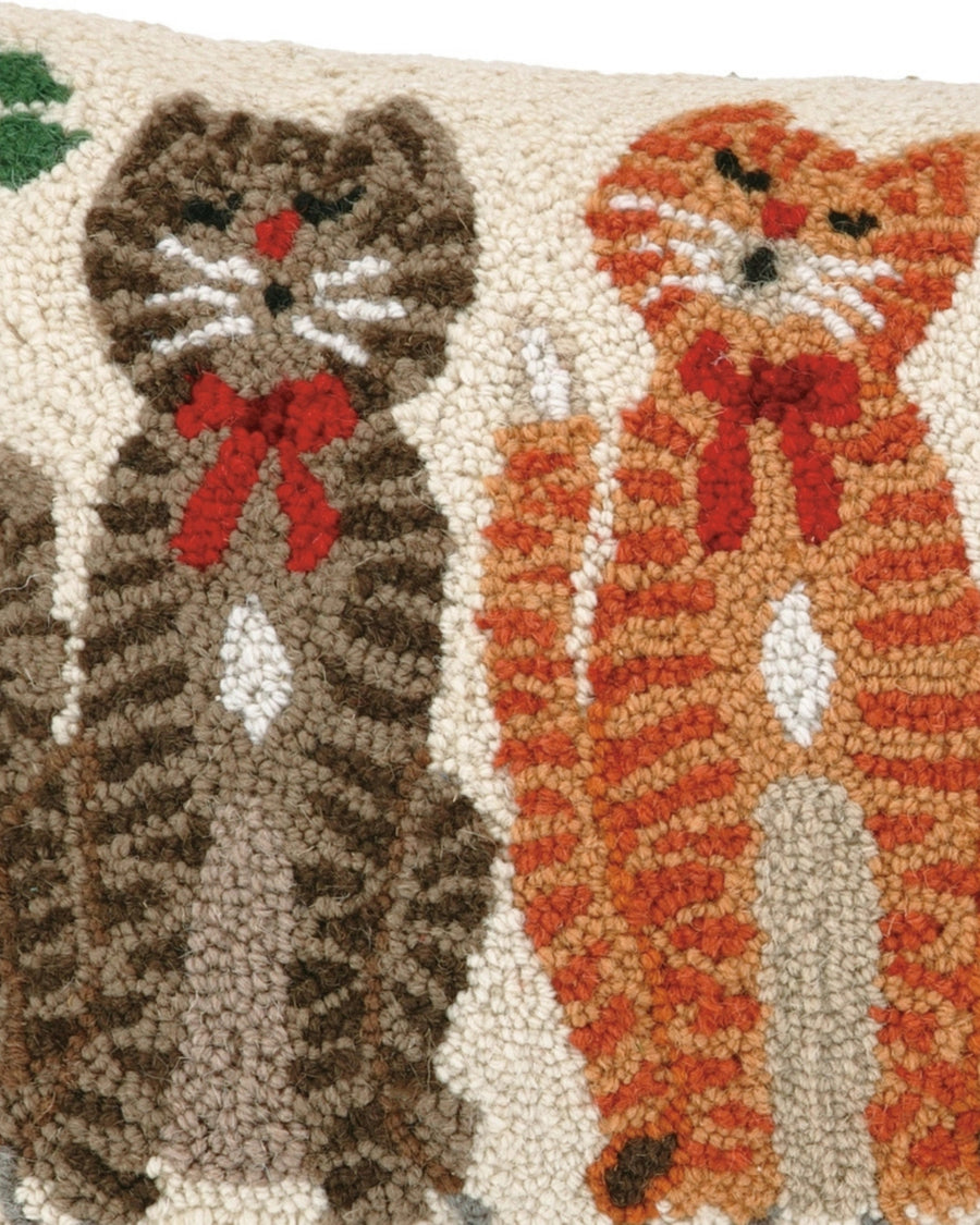 Close-up of brown and orange hooked cats wearing red bows on a pillow