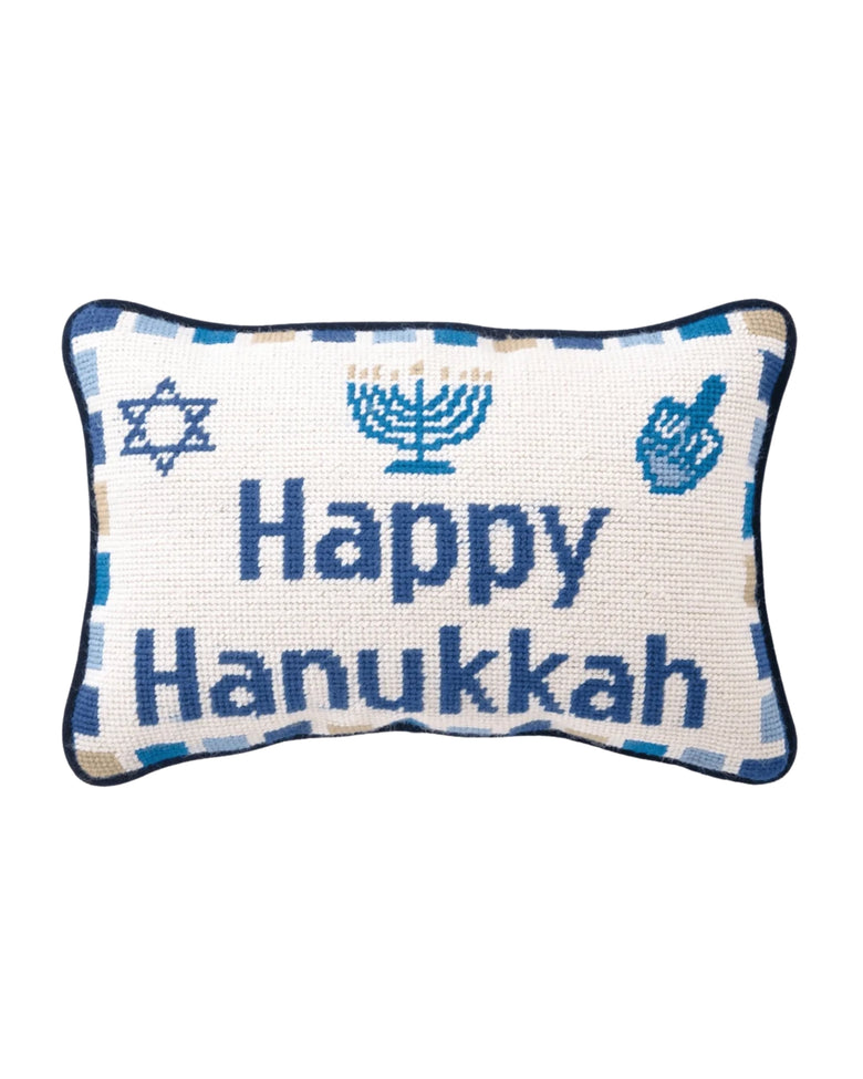 Needlepoint pillow reading “Happy Hanukkah,” with blue Jewish symbols and a blue-and-white border.