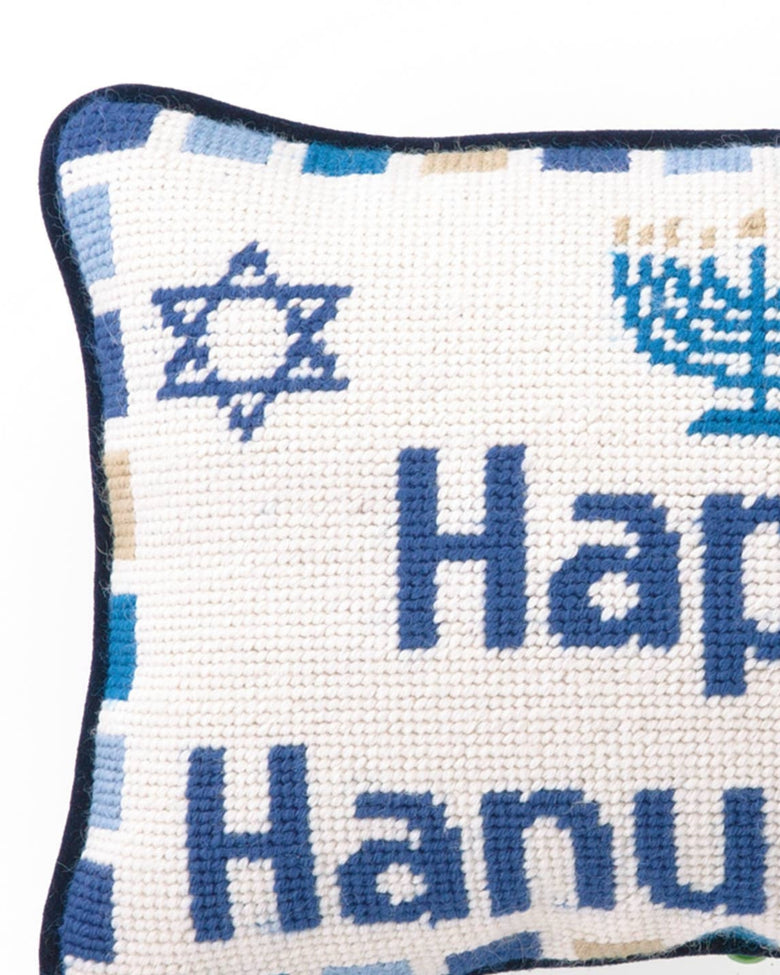 Close-up of the needlepoint pillow showing the words “Happy Hanukkah” and a blue Star of David.