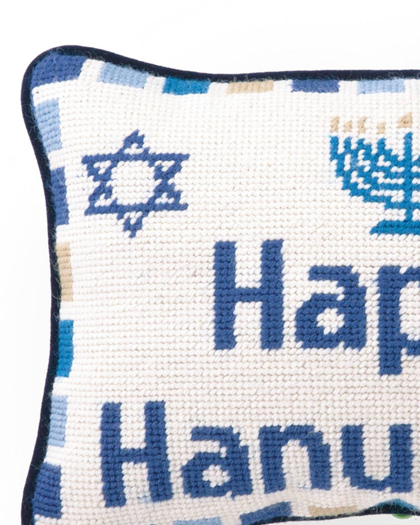Close-up of the needlepoint pillow showing the words “Happy Hanukkah” and a blue Star of David.