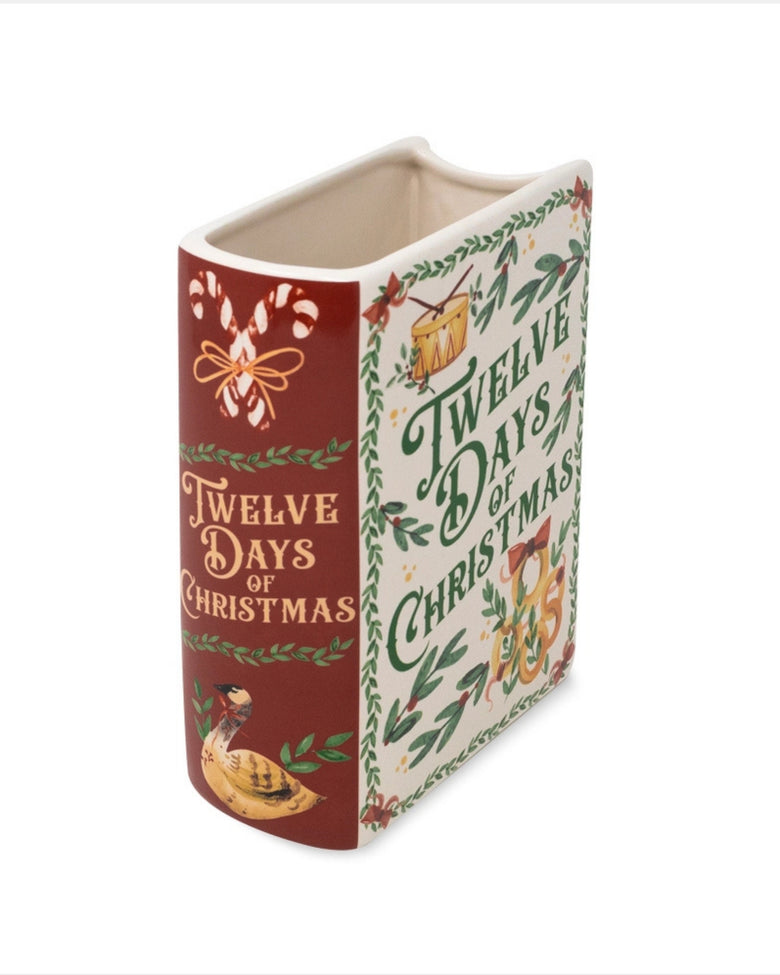 Angled view of the Twelve Days of Christmas book-style vase, showing its open top, illustrated front, and red decorated side.