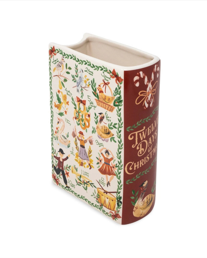 Angled view of the open Twelve Days of Christmas book-style vase, showing the numbered illustrated front panel and red decorated side.