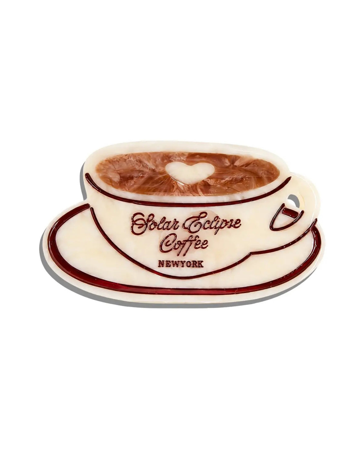 Front view of an ivory coffee-cup-shaped claw hair clip with brown trim and a heart-shaped latte design.