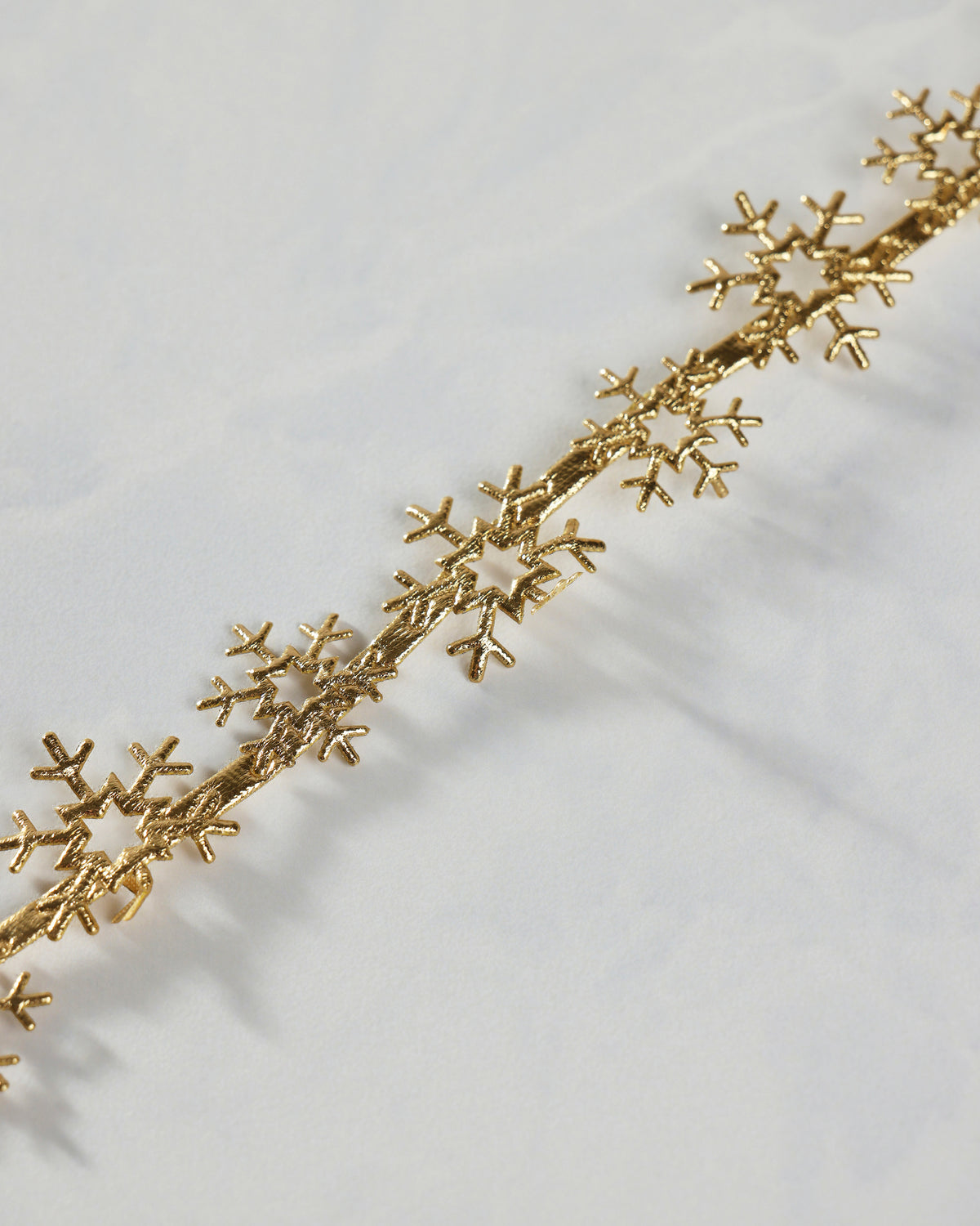 Close-up of gold snowflake trim showing repeated cutout snowflake shapes along the strip.