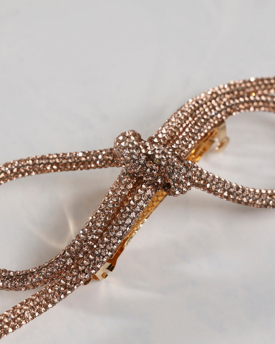 Close-up of the sparkling bow barrette showing faceted embellishments across the bow.