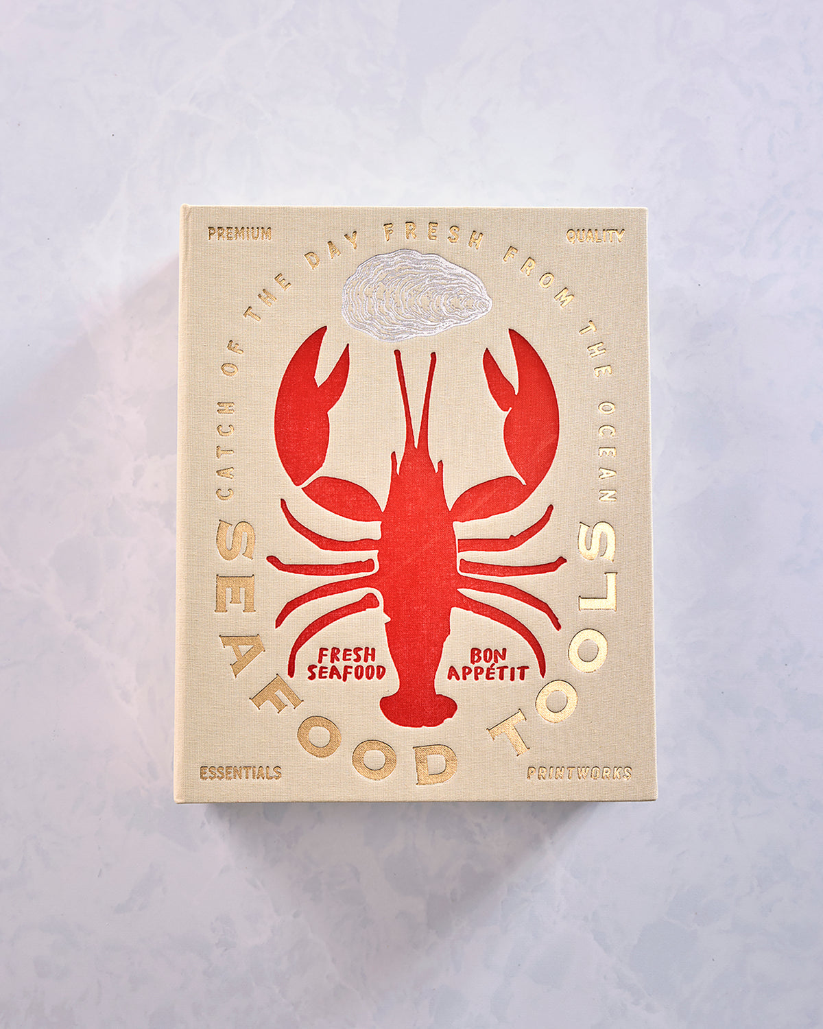 Front view of a closed book-style seafood tools box featuring a red lobster and oyster illustration.