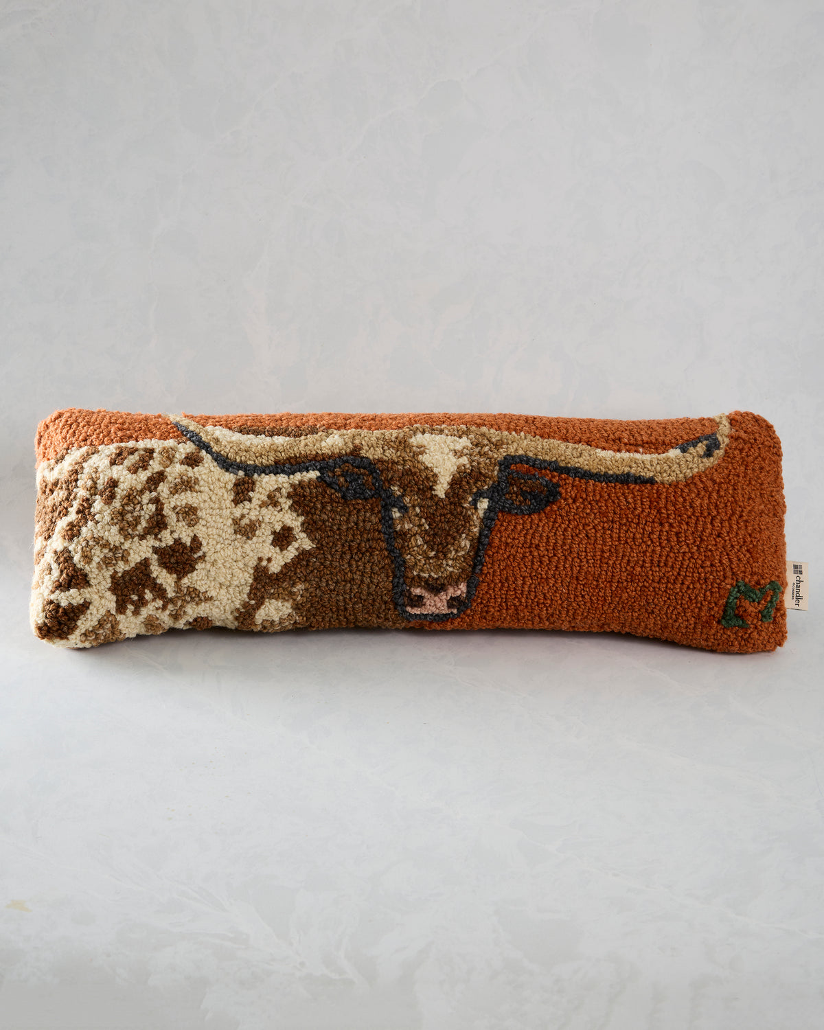 Front view of the lumbar pillow with a longhorn centered on a rust-colored background.