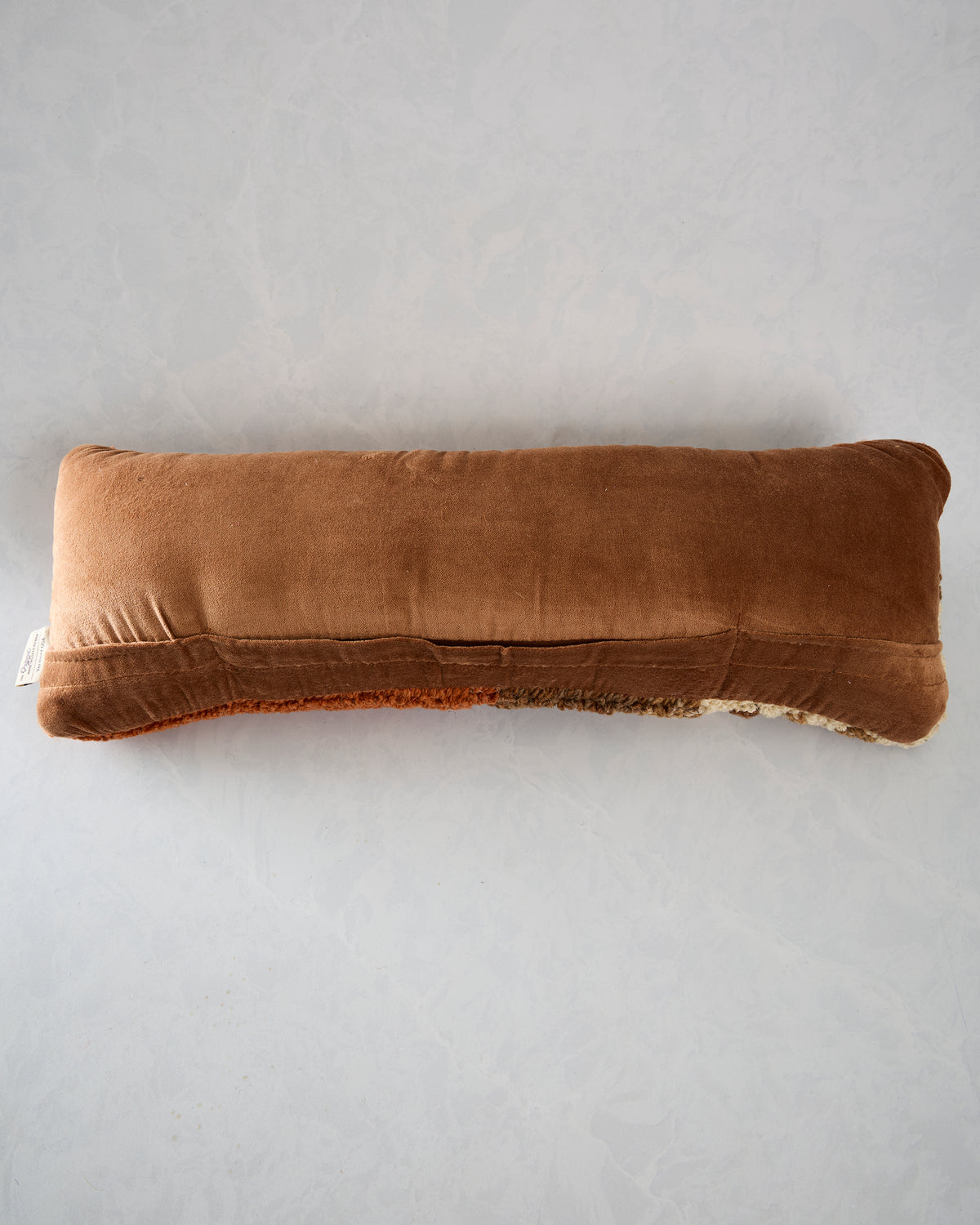 Back view of the longhorn pillow showing its plain brown backing and stitched seam.